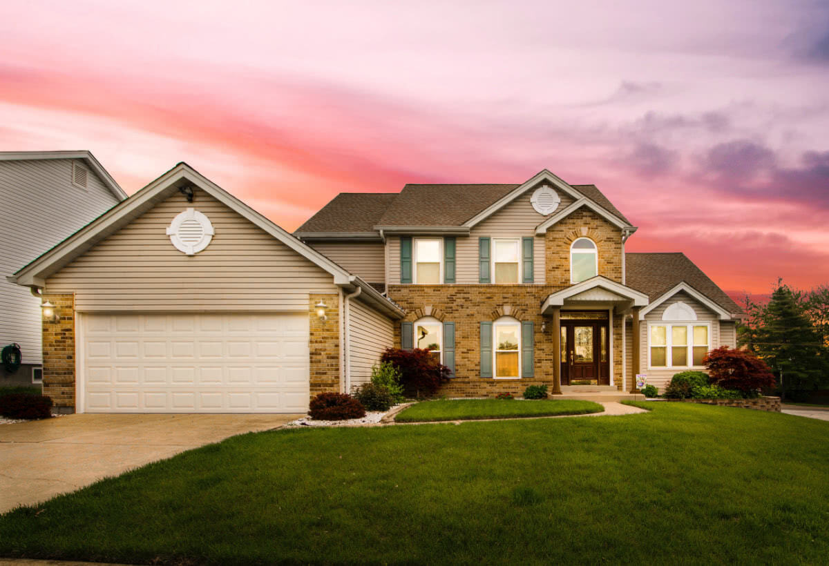 A brick and stone family home at sunset